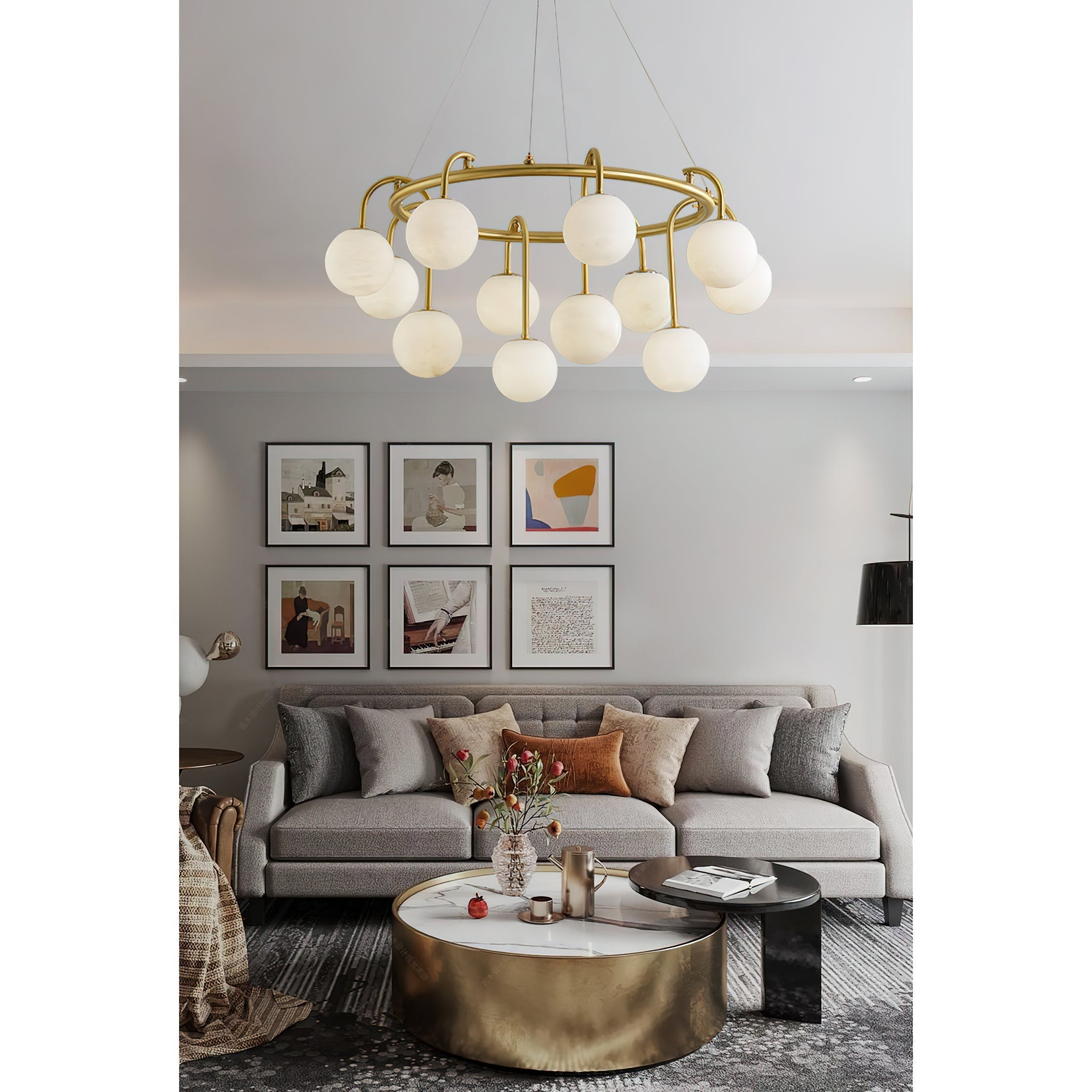 The Clérachic Alabaster Globe Chandelier lit over a grey sofa and round brass table, below a six-frame gallery wall.