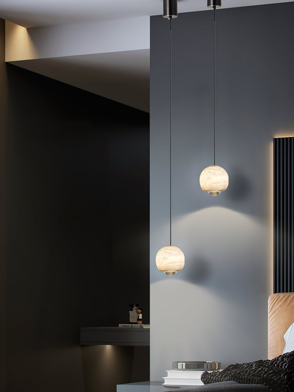 Two Clérachic Alabaster Globe Pendant Lights hung at staggered heights on a dark wall, small warm globes reading clearly against the shadow.
