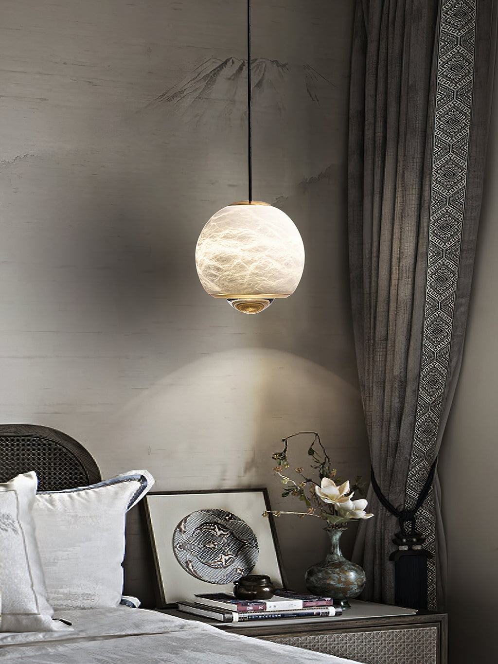 Clérachic Alabaster Globe Pendant Light before a painted mountain mural, the lens laying a bright arc of light across the wall behind it.