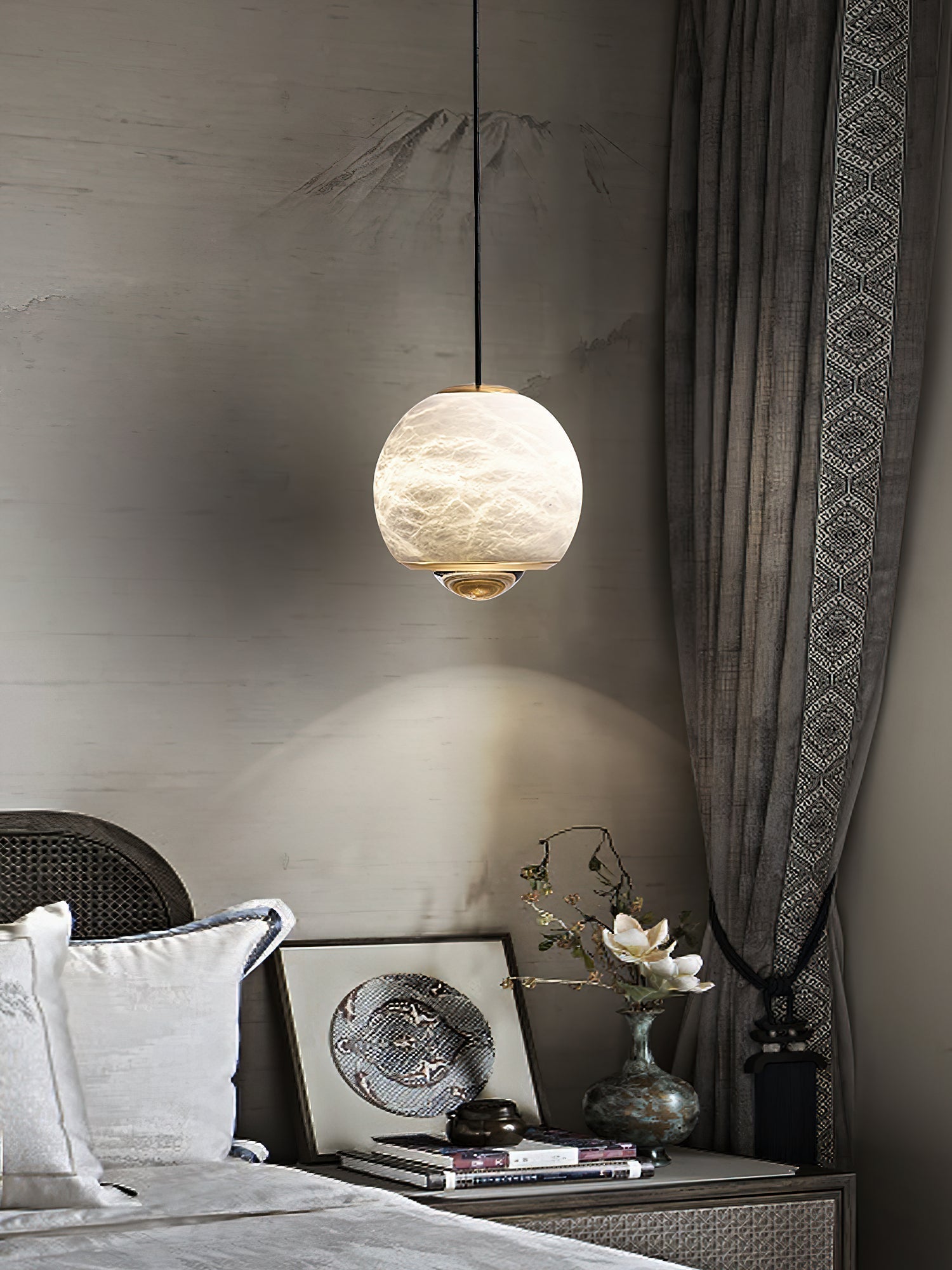 Clérachic Alabaster Globe Pendant Light before a painted mountain mural, the lens laying a bright arc of light across the wall behind it.