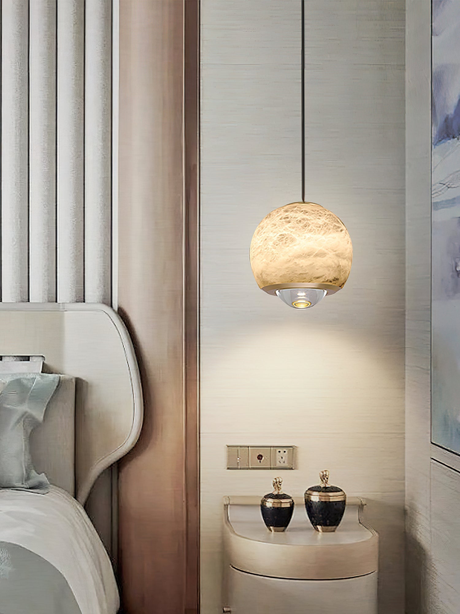 Clérachic Alabaster Globe Pendant Light on a silk-textured wall, the warm stone globe over a curved nightstand and two brass-topped jars.