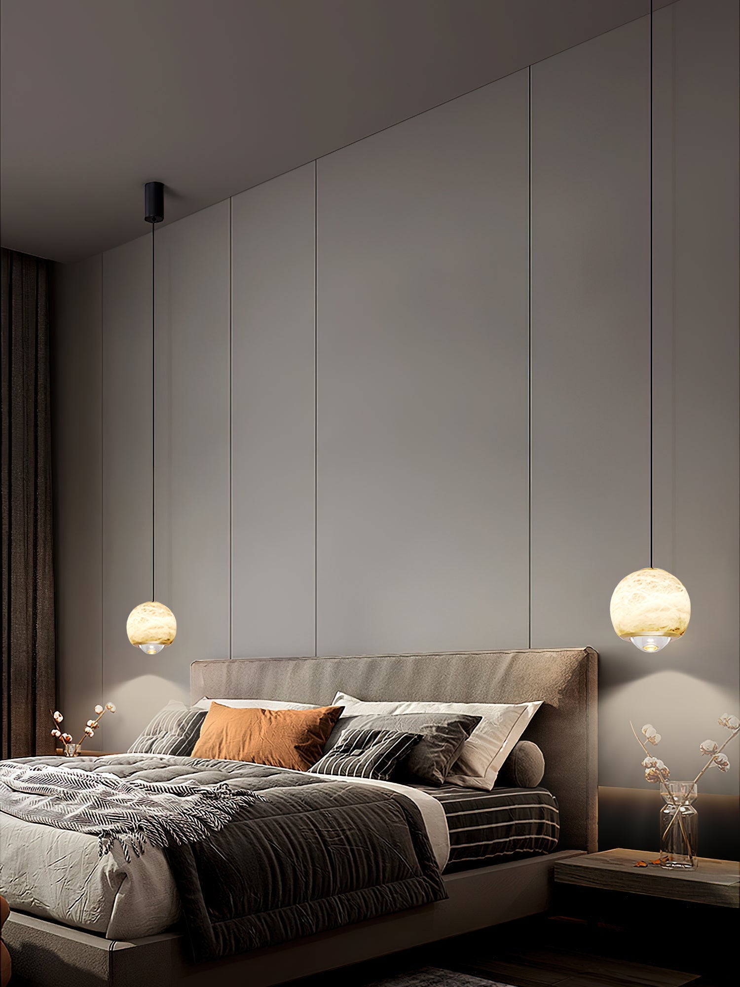 Two Clérachic Alabaster Globe Pendant Lights at different drops flanking a bed in a dim panelled bedroom, each pooling light on the wall.