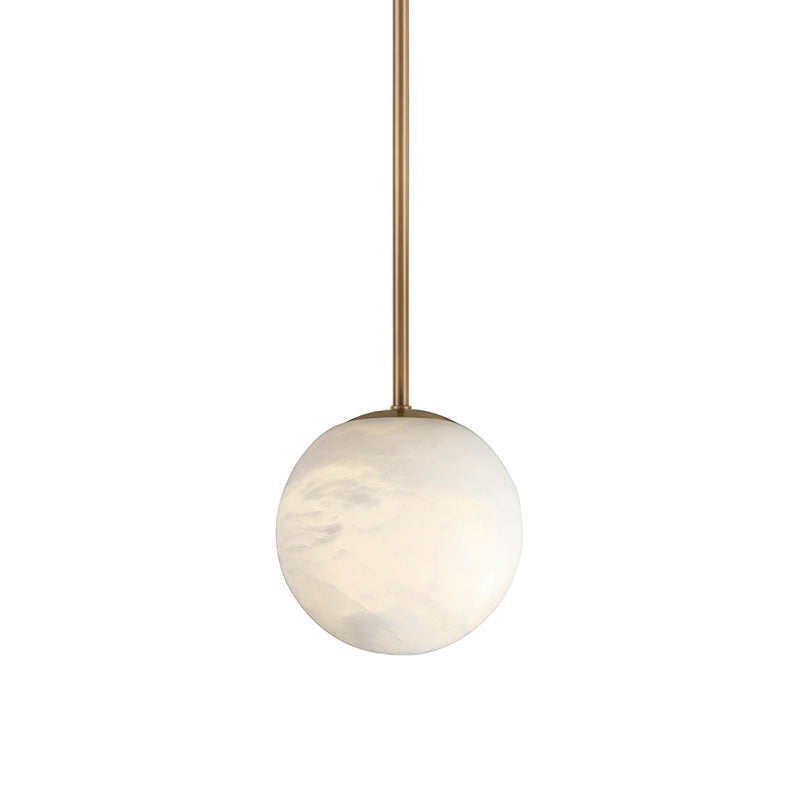 Brass rod suspension of the Clérachic Alabaster Globe Pendant Light, the slim tube dropping straight down to the pale stone sphere.