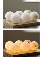 Six stone globes for the Clérachic Alabaster Globe Pendant Light, shown unlit in the top frame and lit warm in the lower one.