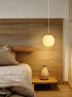 Clérachic Alabaster Globe Pendant Light against oak panelling in a Japanese-style bedroom, lit warm above a ceramic vase.