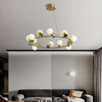Clérachic Alabaster Globe Ring Chandelier lit over a grey sofa in a living room with a fluted wall panel and ochre cushion.