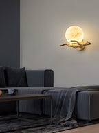 The Clérachic Alabaster Globe Wall Sconce lighting a corner above a charcoal sofa, its warm globe the only light in the room.