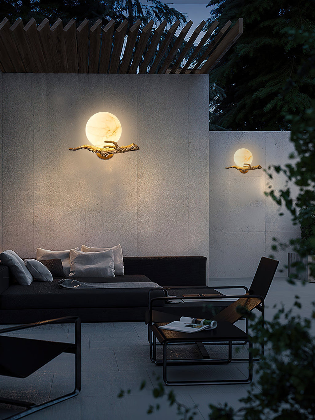 Two Clérachic Alabaster Globe Wall Sconces lit on pale concrete walls in an evening styling shot, warm haloes behind each globe.