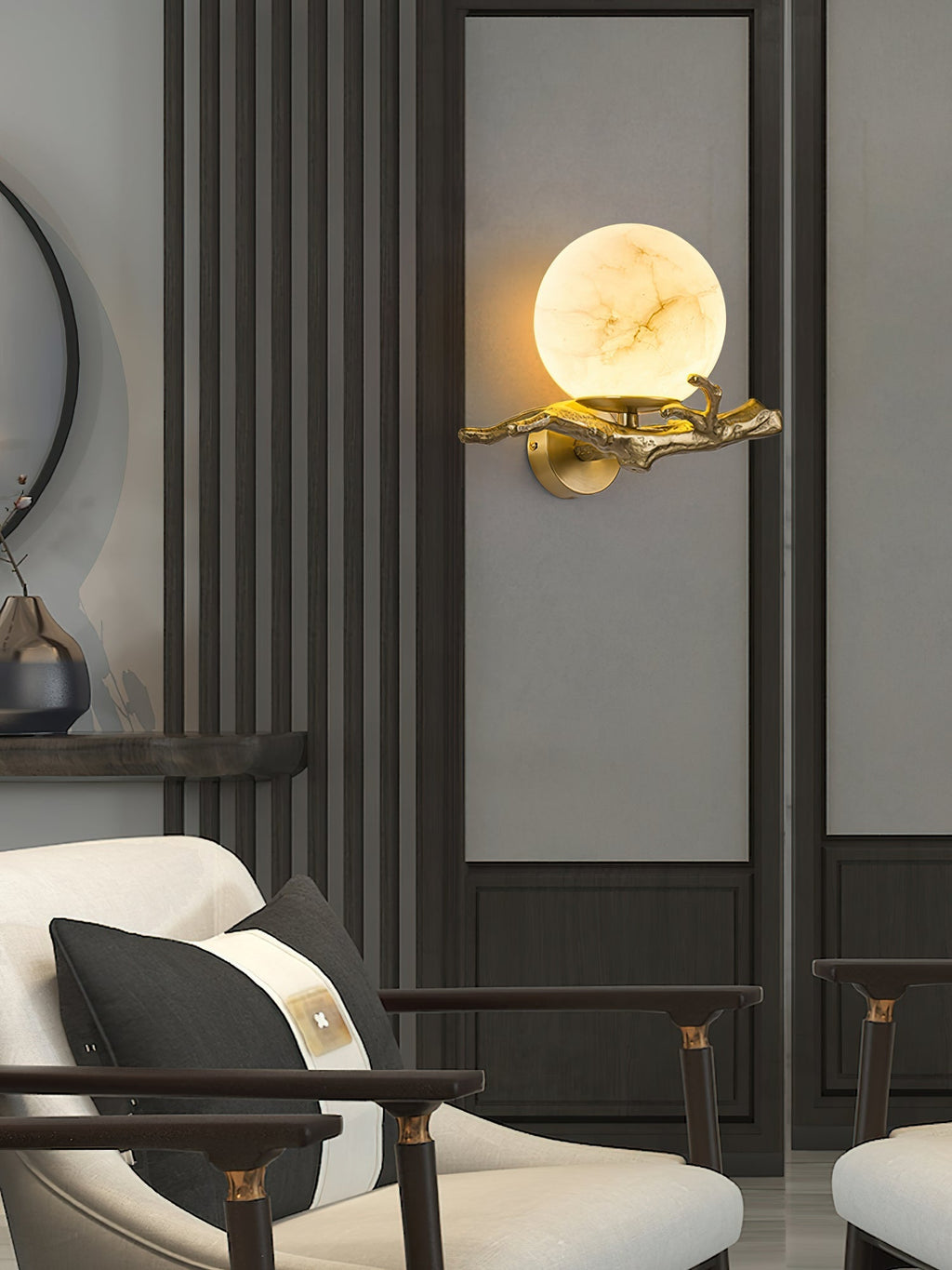The Clérachic Alabaster Globe Wall Sconce centred on a pale wall panel, brass branch and lit globe framed by dark timber fluting.