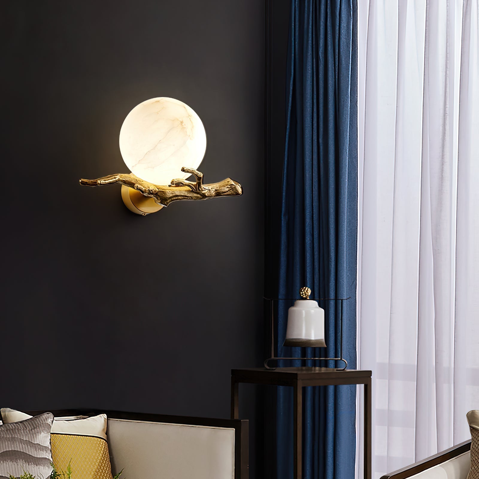 Clérachic Alabaster Globe Wall Sconce alone on a black wall, its warm globe and brass branch reading as wall sculpture after dark.