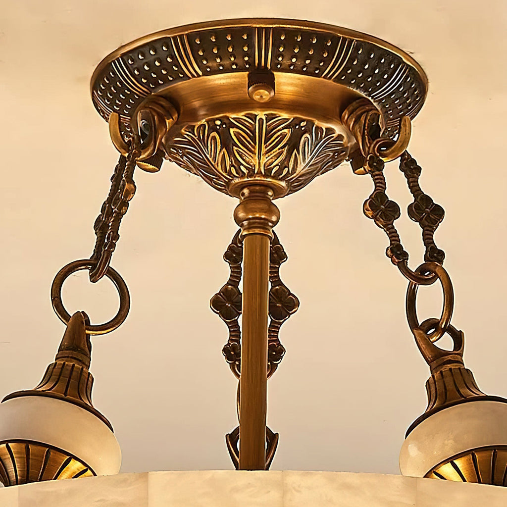 Close view of the patterned brass canopy, chain links and alabaster finials that hold up this Clérachic ceiling light.