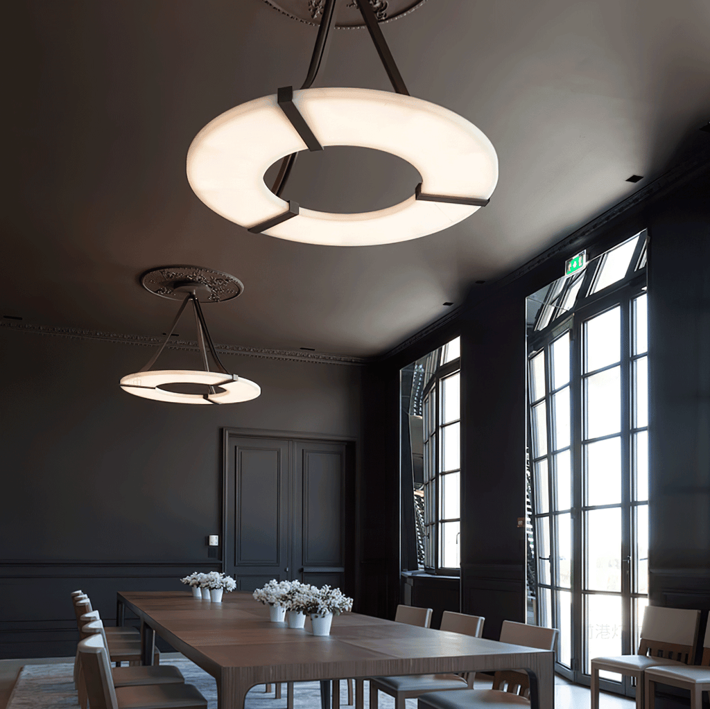 Two Clérachic halo pendants lit above a long dining table in a dark panelled room.