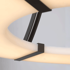 Close-up of the Clérachic halo pendant where a bronze strap crosses the lit stone ring.