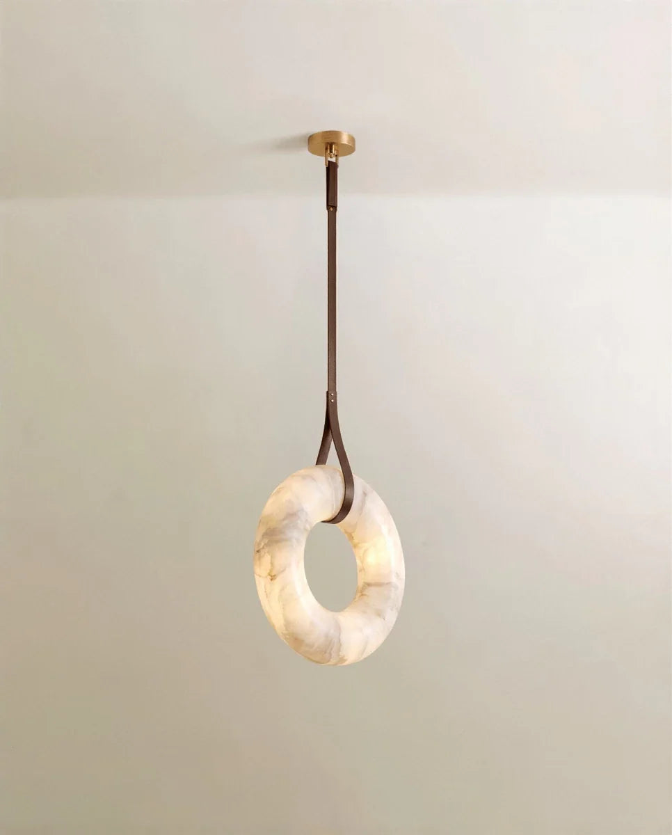 Clérachic alabaster ring pendant hanging from one dark brown leather strap and a round gold canopy, lit from within.