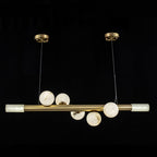 Five alabaster globes along the Clérachic Alabaster Linear Bar Pendant Light, with a lit stone cylinder closing each end of the bar.