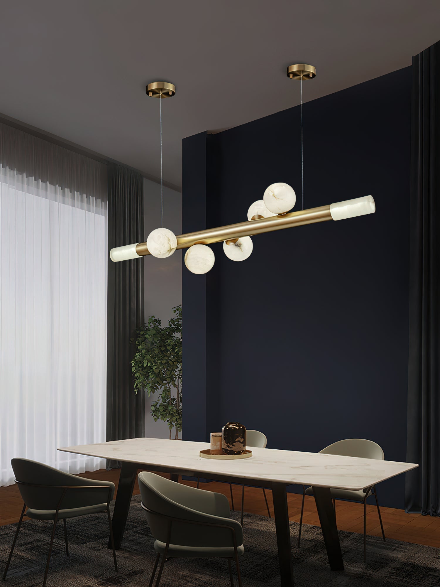 Clérachic Alabaster Linear Bar Pendant Light running the length of a marble dining table in a dark blue room by tall curtains.