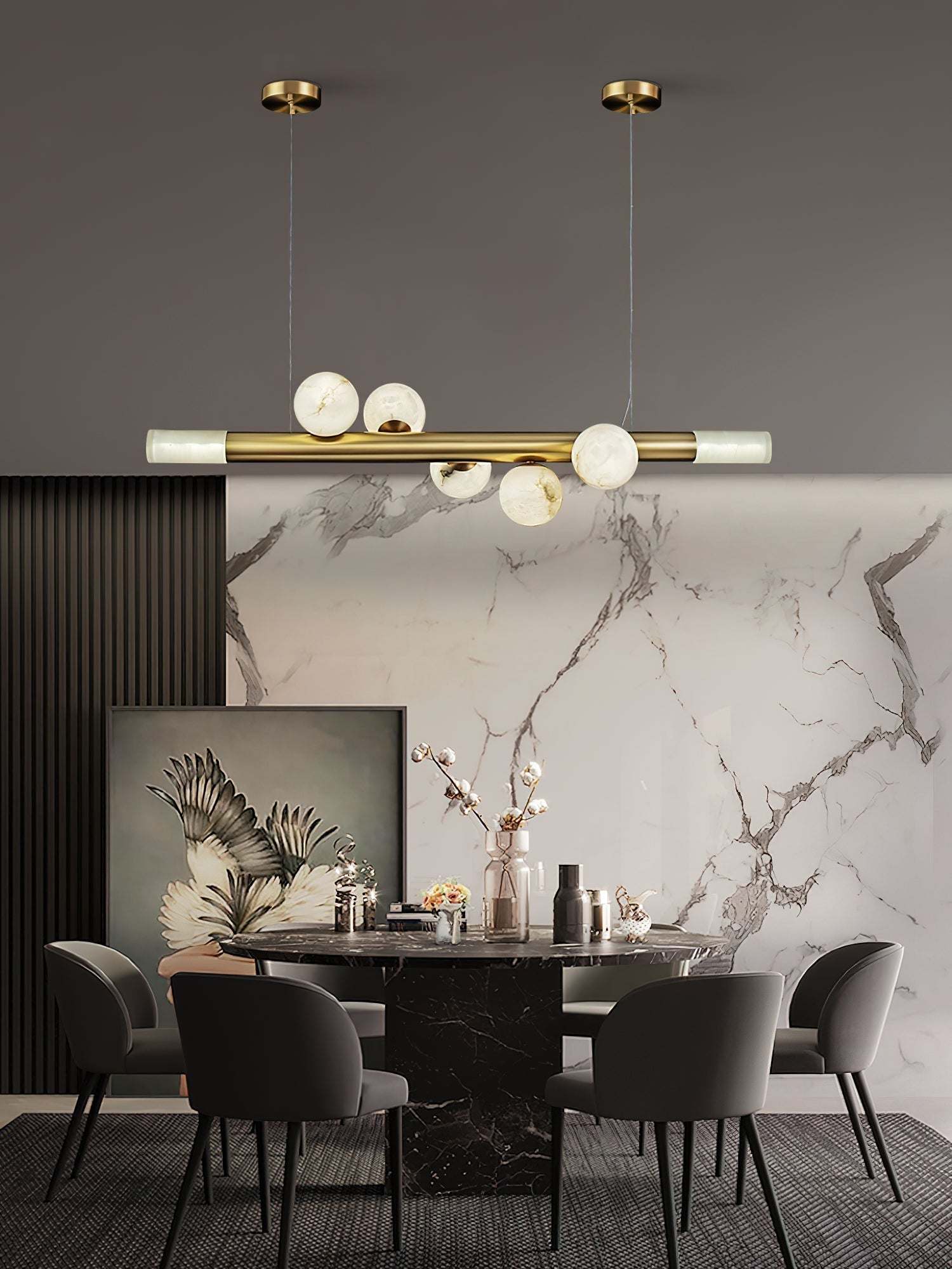 Clérachic Alabaster Linear Bar Pendant Light above a round black marble table, set against a veined marble slab wall.