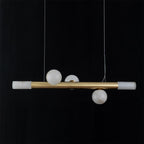 Clérachic Alabaster Linear Bar Pendant Light photographed level on black, three stone globes clustered at the centre of the brass bar.