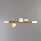 Three-globe Clérachic Alabaster Linear Bar Pendant Light on a soft grey backdrop, two stones above the bar and one below.