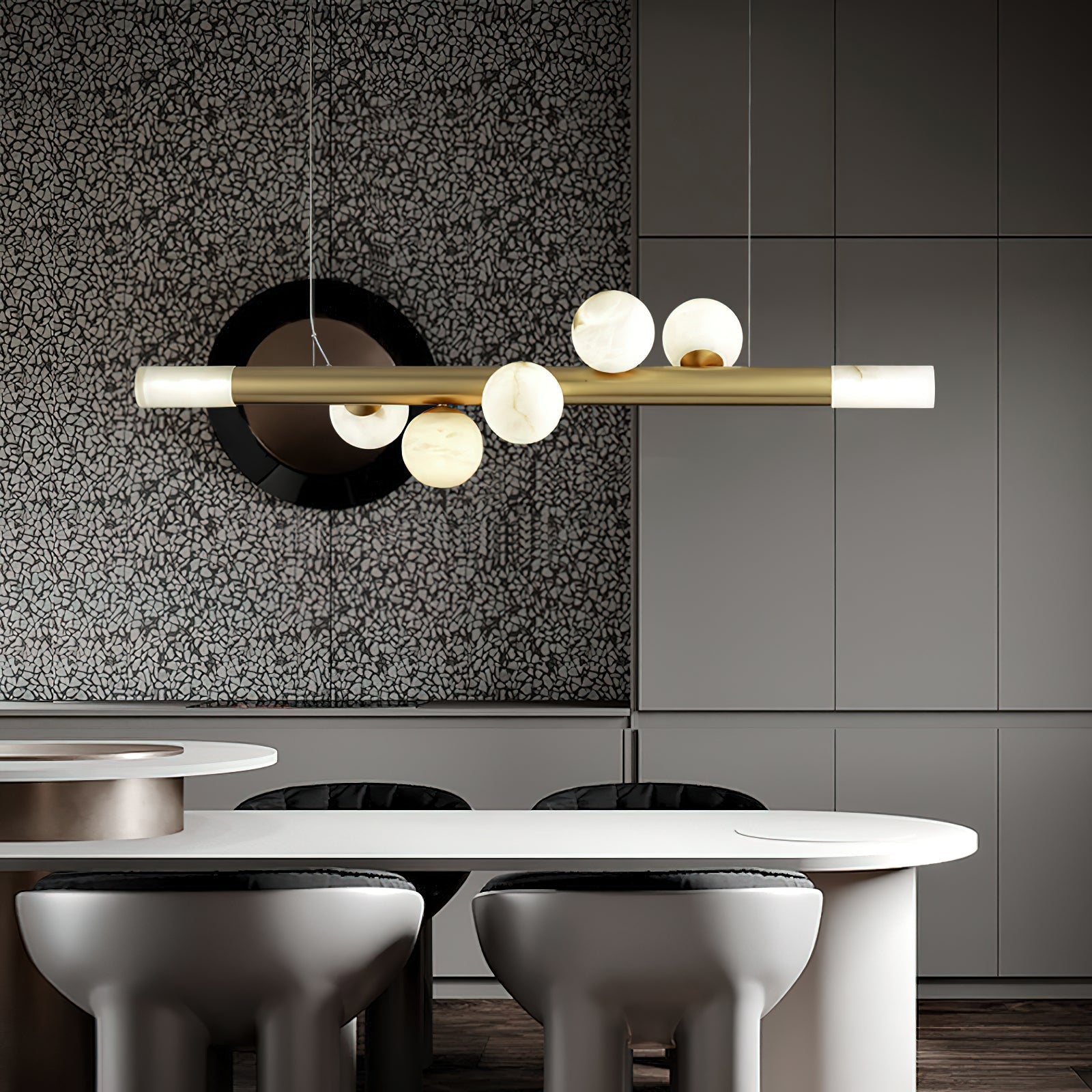 Clérachic Alabaster Linear Bar Pendant Light over a white oval kitchen table, hung against a terrazzo and grey cabinet wall.