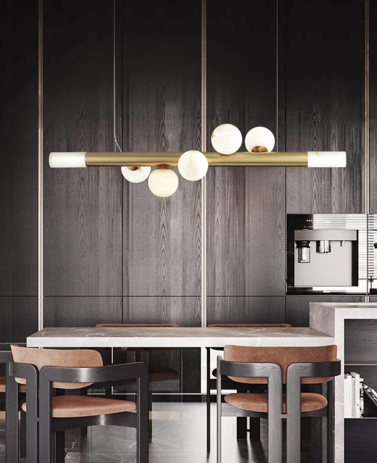 Clérachic Alabaster Linear Bar Pendant Light over a marble table in a dark oak kitchen with tan leather chairs.
