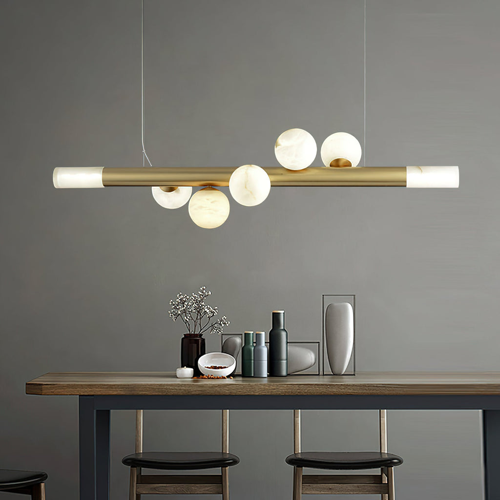 Clérachic Alabaster Linear Bar Pendant Light over a high wooden table and stools, hanging level against a plain grey wall.