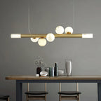 Clérachic Alabaster Linear Bar Pendant Light over a high wooden table and stools, hanging level against a plain grey wall.