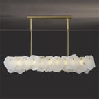 The Clérachic alabaster linear chandelier glowing in a dim room, its LED pushing an even band of light through the stone