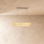 Clérachic rectangular alabaster chandelier on two steel cables with a slim metal canopy, glowing warm against limewash.