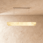 Clérachic long rectangular alabaster chandelier with a stepped stone shade, glowing evenly against plaster.