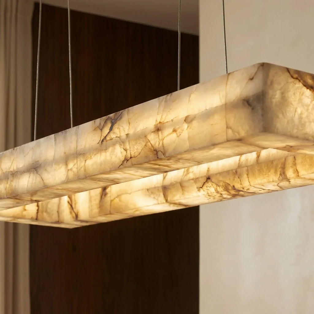 Close view of the Clérachic alabaster chandelier, warm light showing the natural veining of the stone shade.