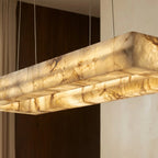 Close view of the Clérachic alabaster chandelier, warm light showing the natural veining of the stone shade.