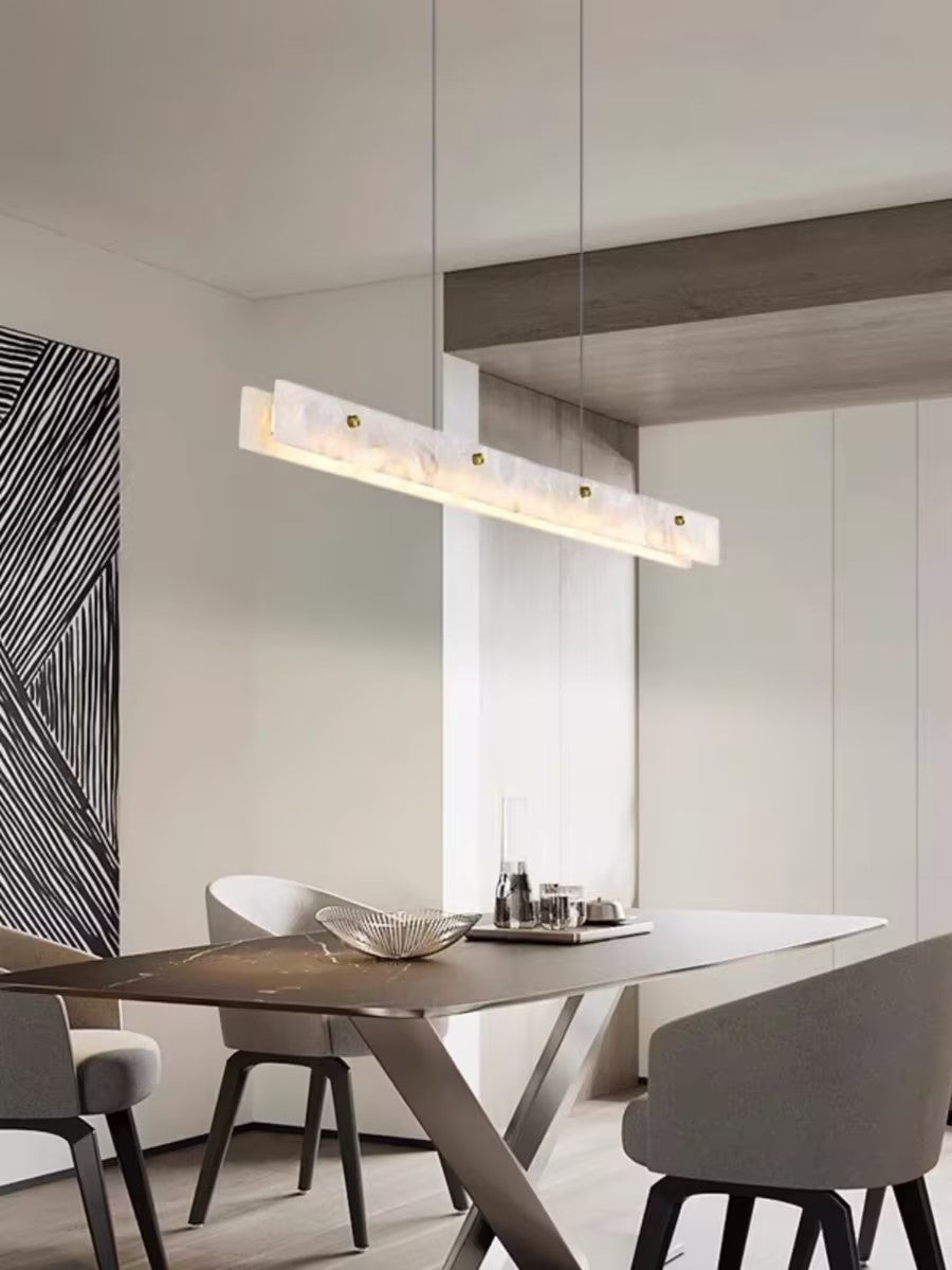 Clérachic alabaster bar over a walnut dining table, warm light beside a graphic black-and-white wall panel.