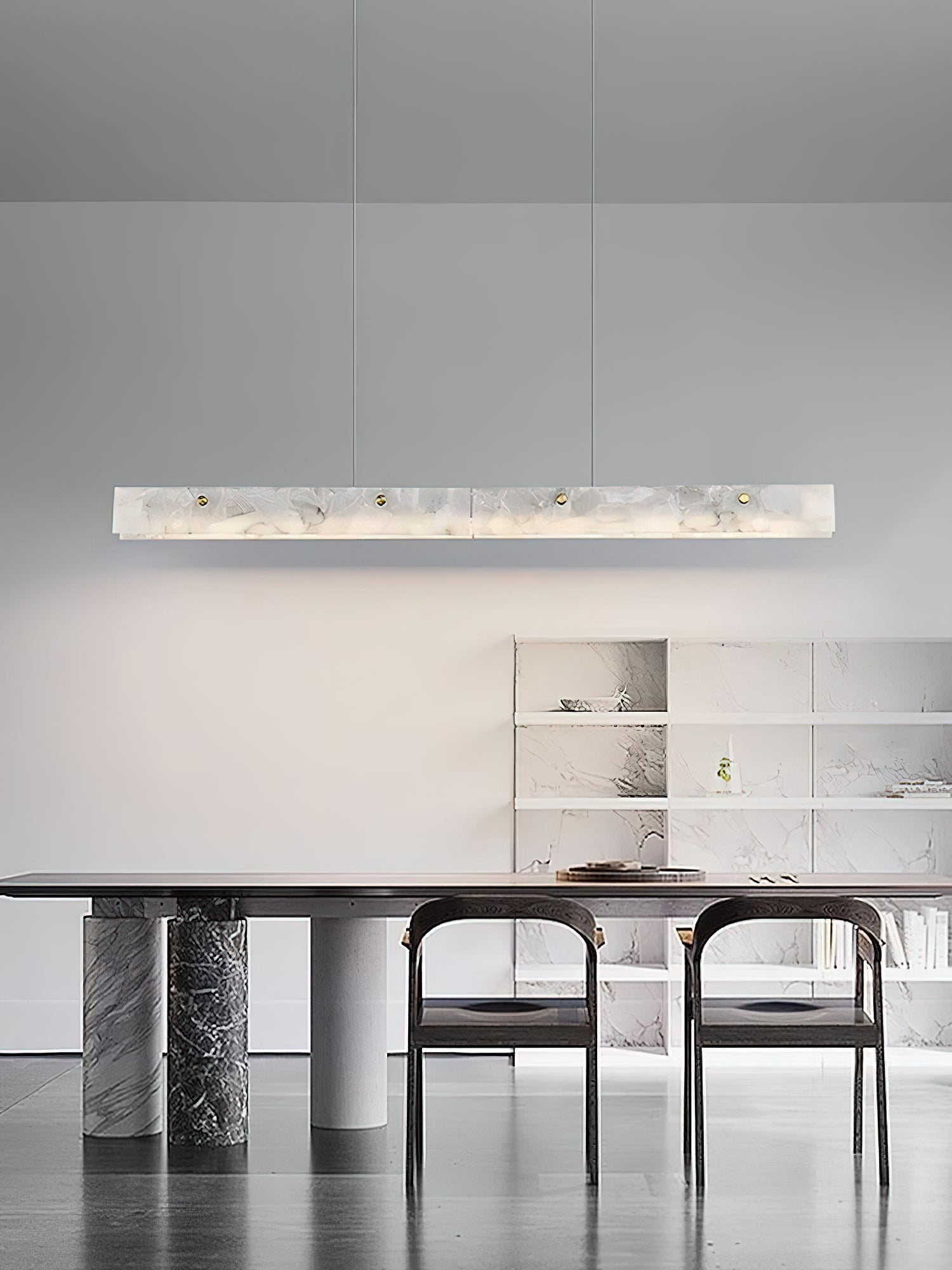 The Clérachic bar glowing above a marble-base dining table, with open shelving along the wall behind.