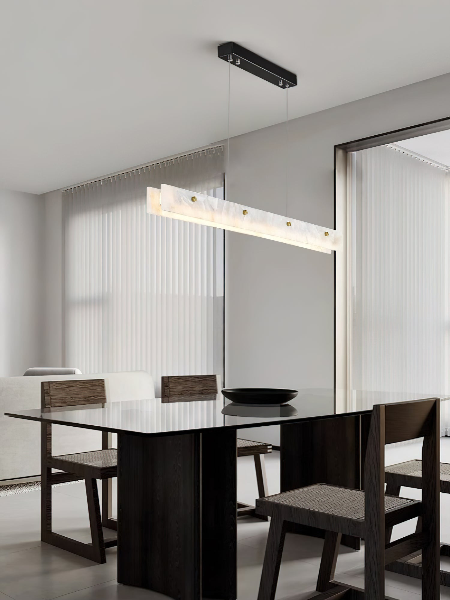 Clérachic pendant seen at an angle in a dining room, dark timber table below and fluted glazing to one side.