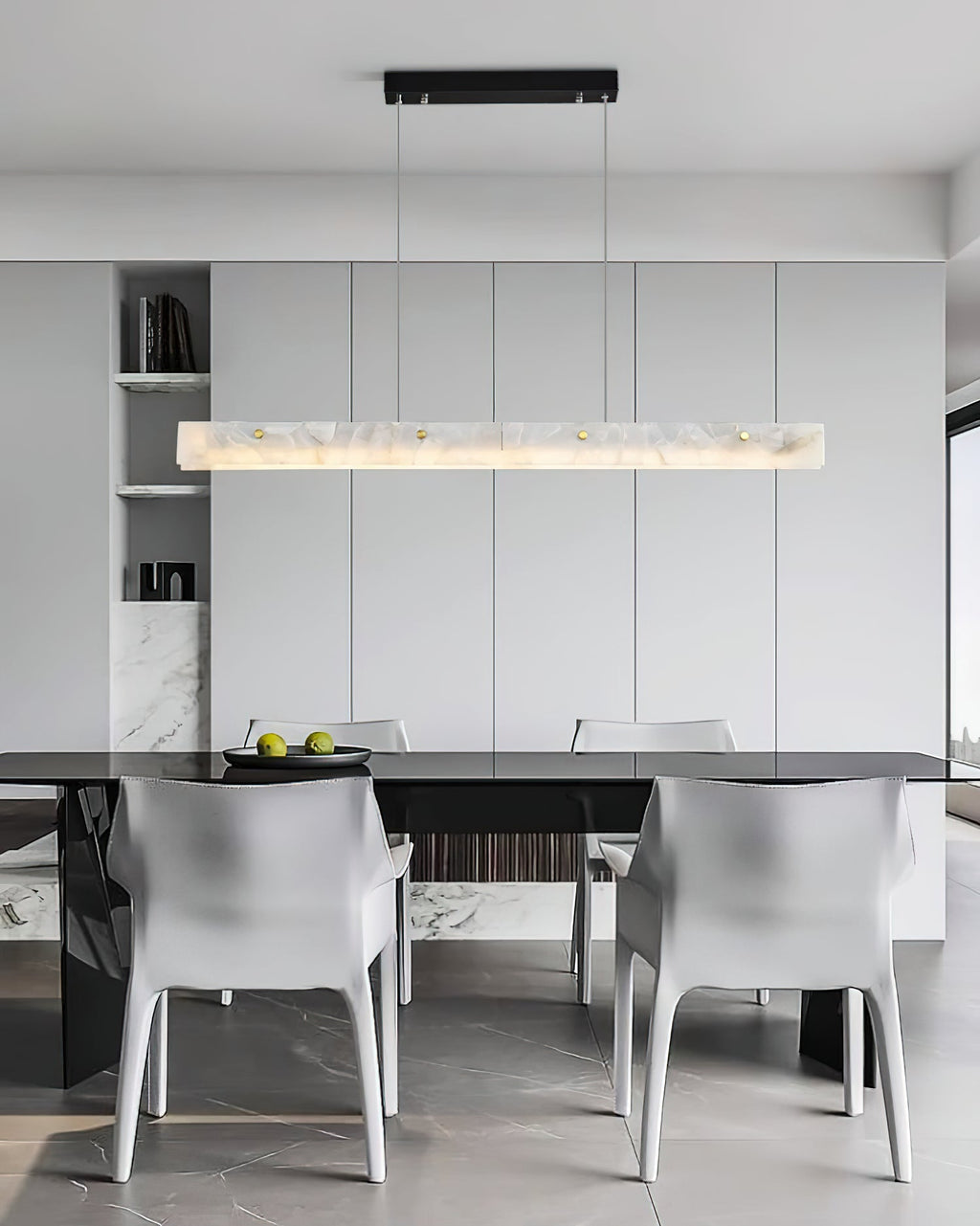 Clérachic alabaster pendant over a dark dining table with white armchairs on pale marble flooring.