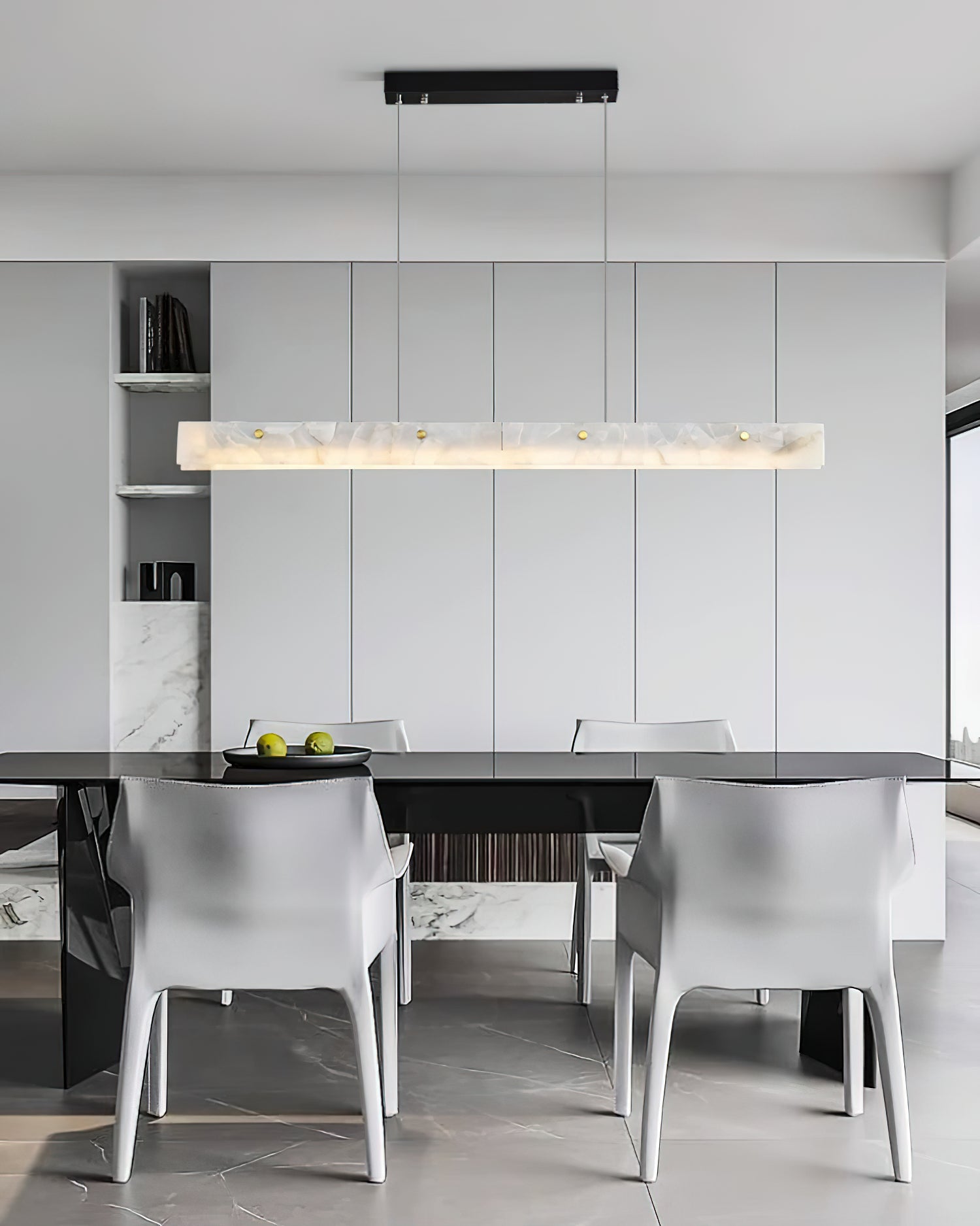 Clérachic alabaster pendant over a dark dining table with white armchairs on pale marble flooring.