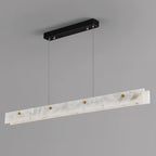 The Clérachic pendant from below and to one side, showing the black canopy, steel cables and brass thumb studs unlit.