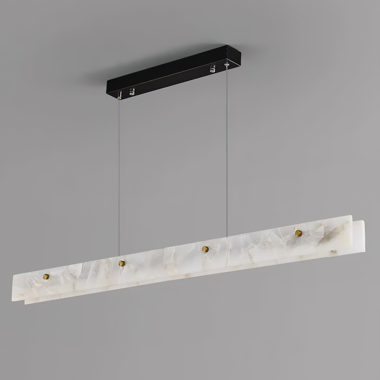 The Clérachic pendant from below and to one side, showing the black canopy, steel cables and brass thumb studs unlit.