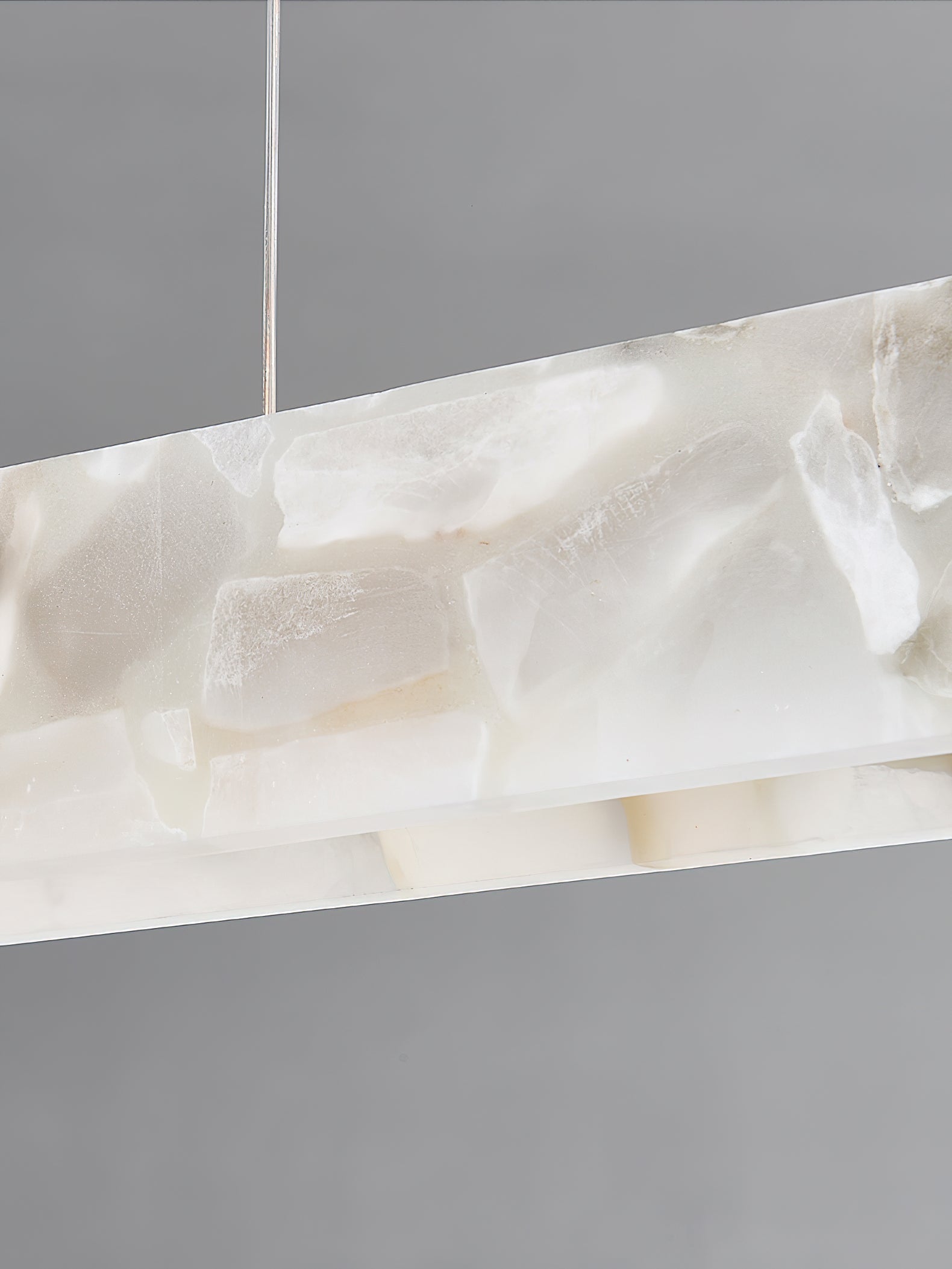Clérachic alabaster panel photographed close, its translucent veining and mineral cloudiness lit from within.