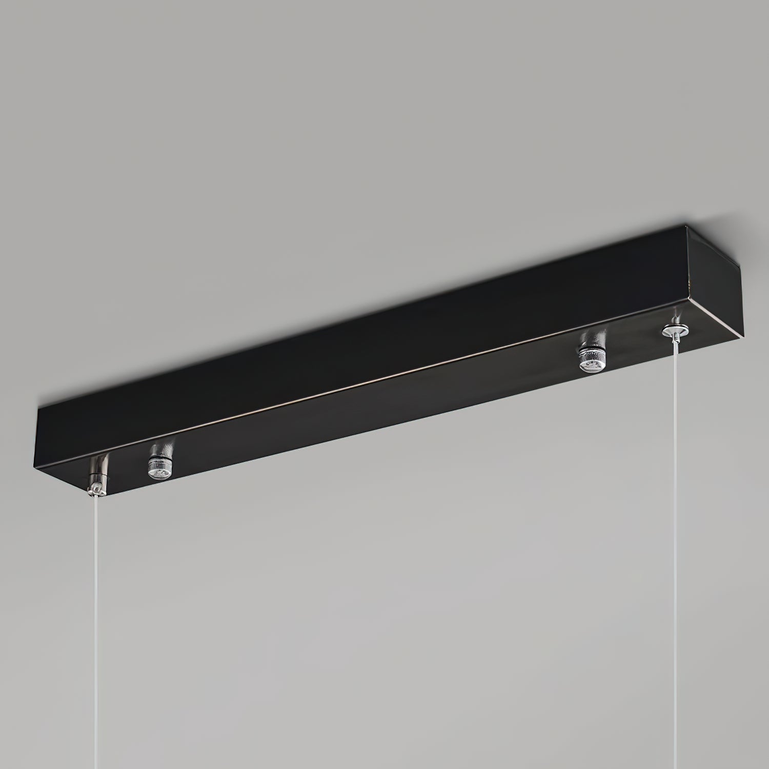 The Clérachic canopy in close-up, a slim matte black bar with the two suspension cables leaving its underside.