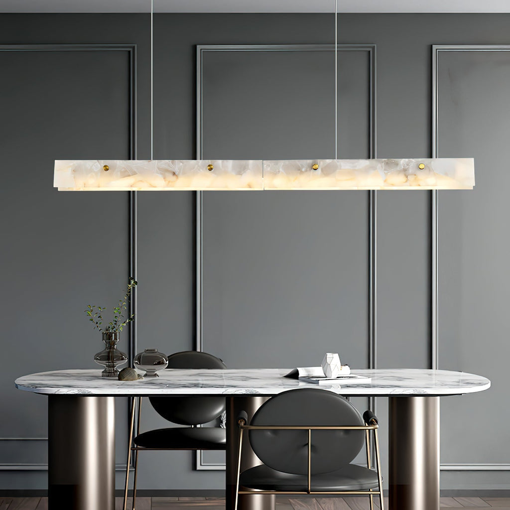 The Clérachic pendant lit above an oval marble table in a grey panelled dining room.