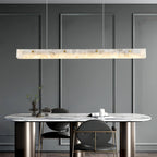 The Clérachic pendant lit above an oval marble table in a grey panelled dining room.