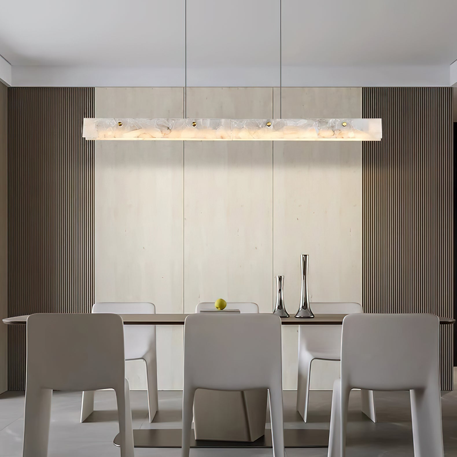 Clérachic linear light over a dining table set before a fluted timber wall, chairs in soft grey below.