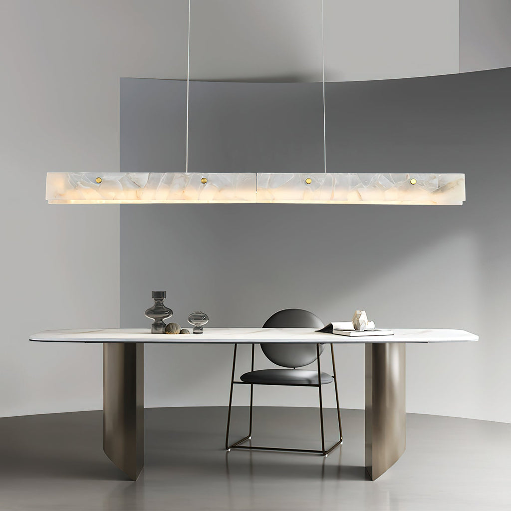 Clérachic pendant suspended in a curved grey room above a pale stone table with a single low chair.