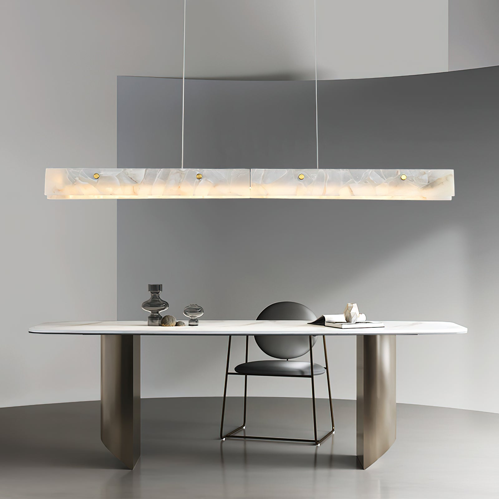 Clérachic pendant suspended in a curved grey room above a pale stone table with a single low chair.
