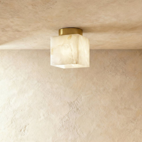 Clérachic square veined alabaster ceiling light on a round brushed brass canopy, glowing softly against a limewash ceiling.