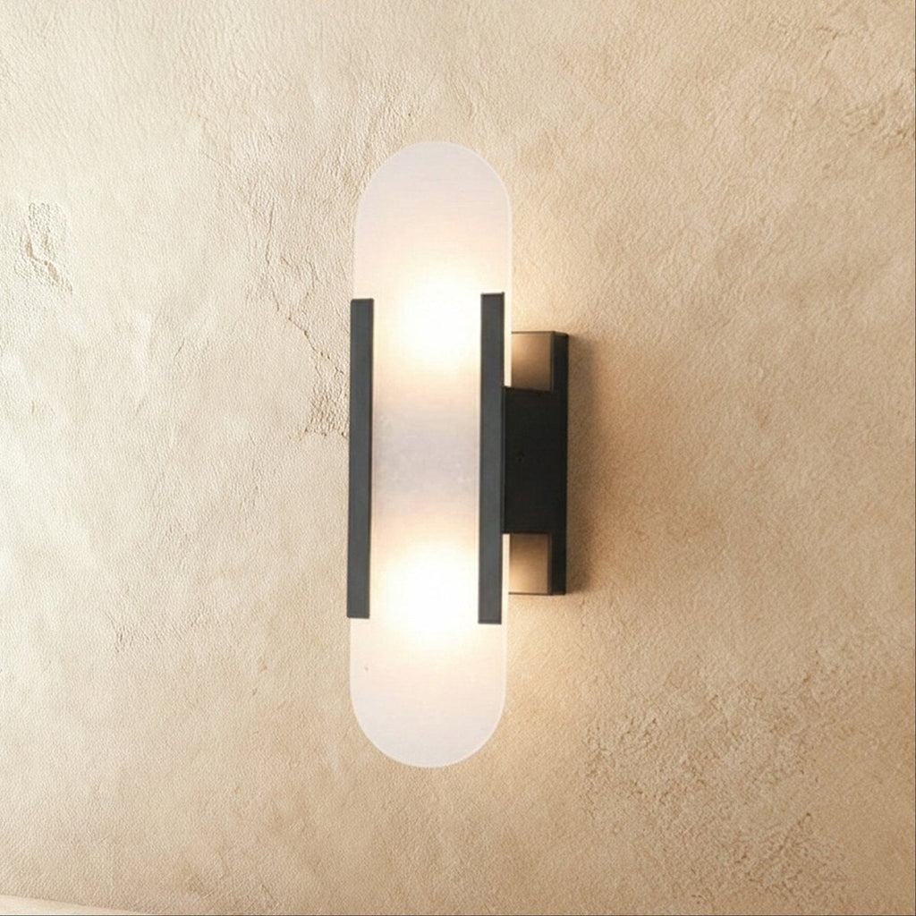 Clérachic wall light with a frosted pill-shaped alabaster shade, black metal bars and a black wall plate.