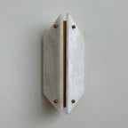 Unlit Clérachic alabaster wall sconce reading as sculpture, a pale faceted shield standing just off a plaster wall.