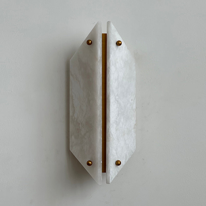 Unlit Clérachic alabaster wall sconce reading as sculpture, a pale faceted shield standing just off a plaster wall.